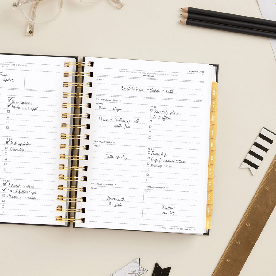 Day Designer 2026 mini weekly planner: classic black pebble texture opened with writing on it