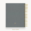 A gray textured notebook with gold spiral binding on the right side, shown against a white background with the text 'BACK COVER' below.