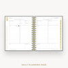 An open spiral-bound planner showing two daily planning pages with gold rings and gold accent lines, photographed on a light gray background with the text 'DAILY PLANNING PAGE' below.