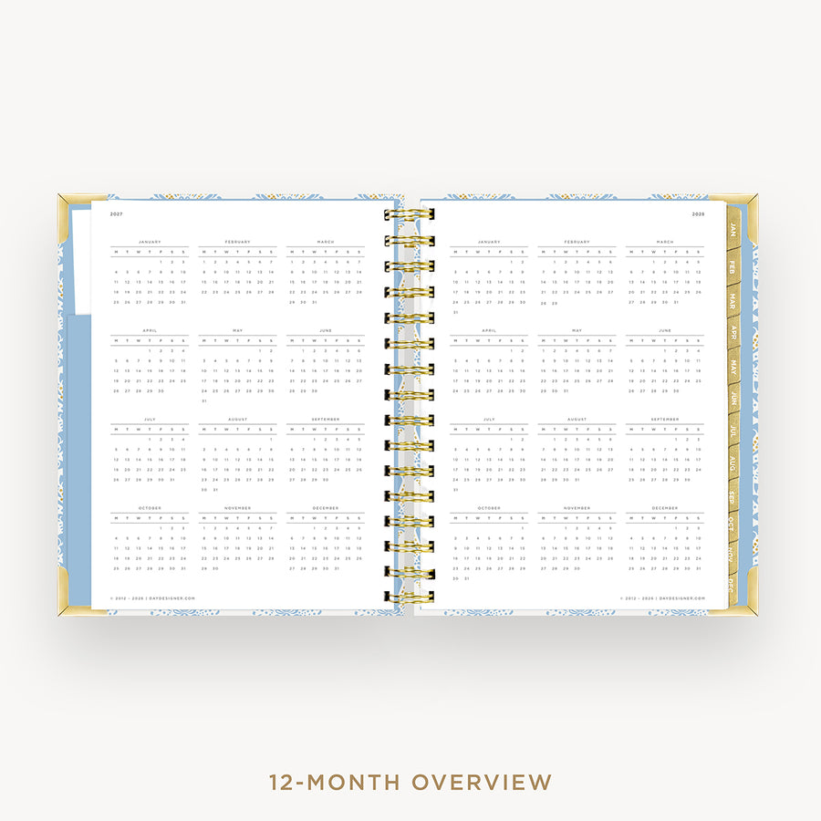 An open spiral-bound planner showing a 12-month overview calendar spread on a light gray background, with the text '12-MONTH OVERVIEW' below.