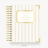 A spiral-bound planner or notebook shown from the front on a clean white background. The cover has vertical cream and beige stripes with a gold border and a central gold label reading 'DAY DESIGNER.
