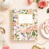 Floral notebook with 'Day Designer' branding on a decorative table setting.
