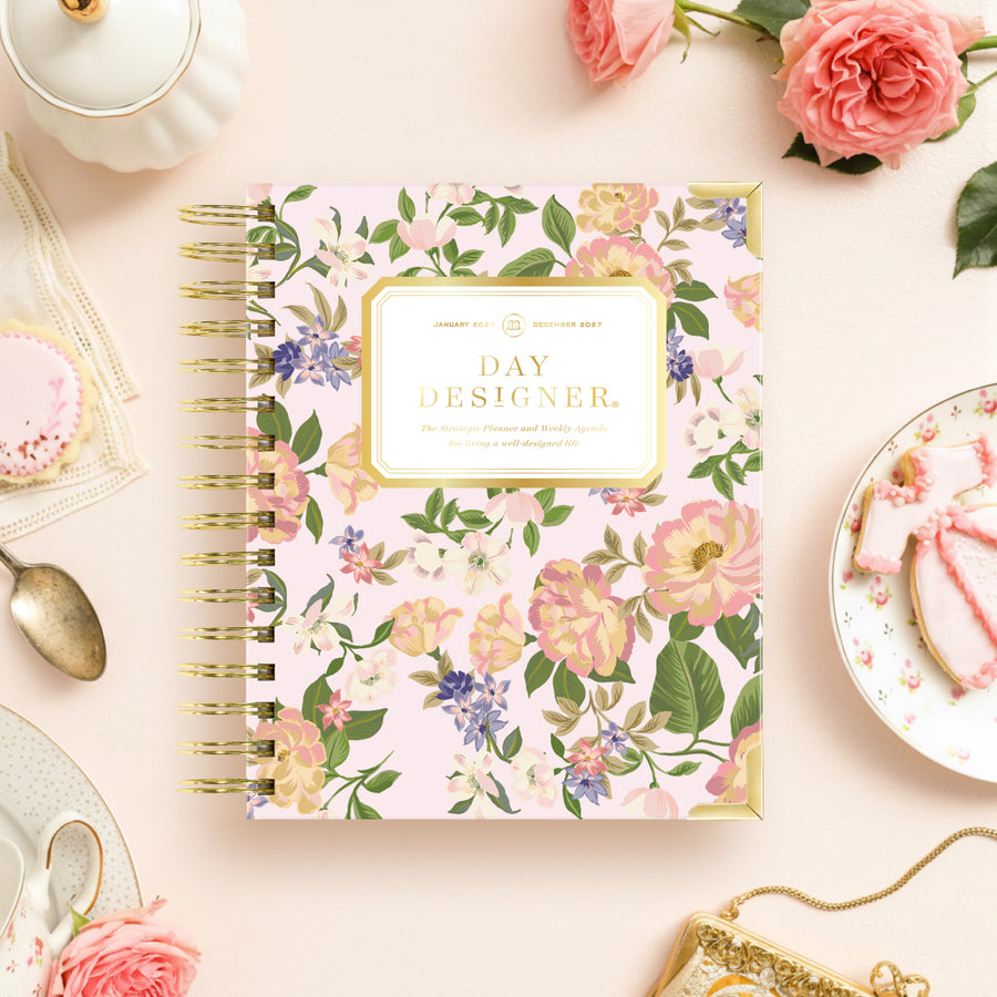 Floral notebook with 'Day Designer' branding on a decorative table setting.