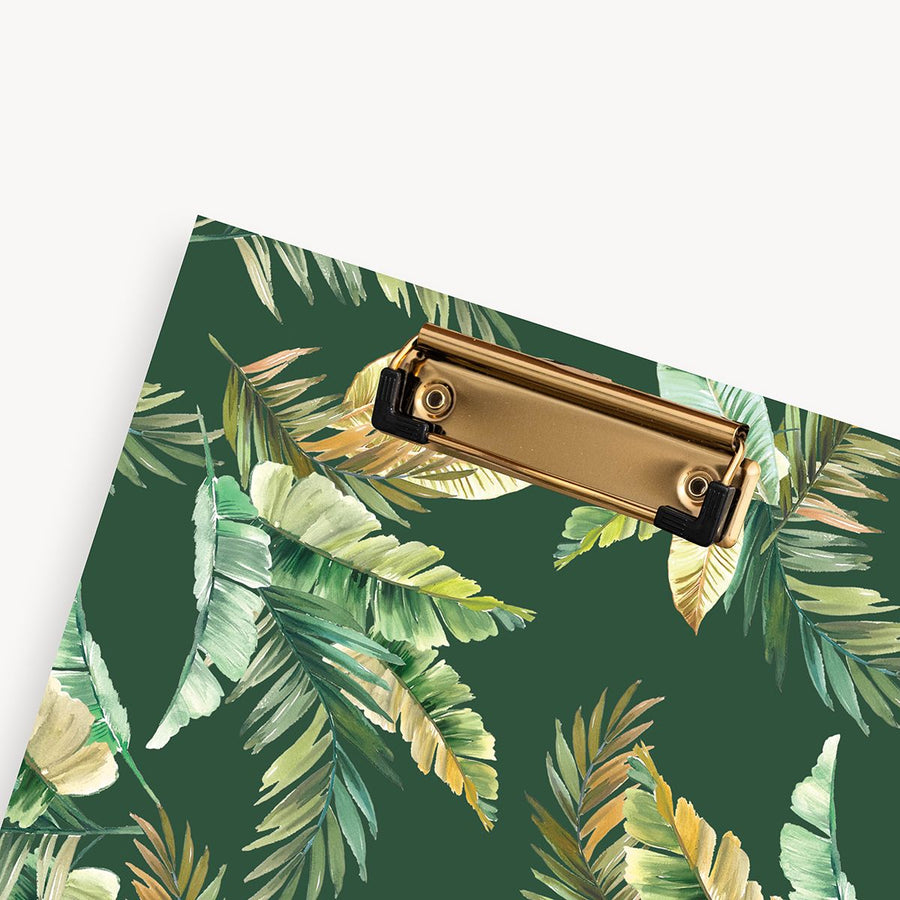 close up of green and gold palm leaves pattern clipfolio with gold clip on a dark green background 