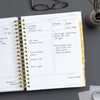 Day Designer 2026 daily planner: charcoal bookcloth opened with writing on it