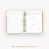 Open planner showing self-assessment worksheets with a colorful cover