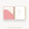 Open planner with pink cover and gold accents on a white background
