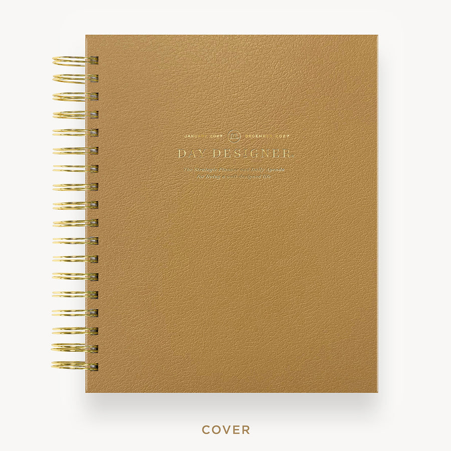 Brown planner with gold spiral binding  and visible day designer branding on a white background