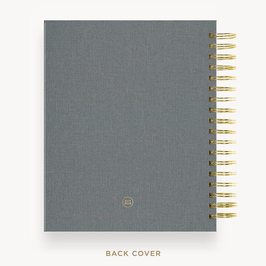 Gray planner with gold spiral binding on a white background