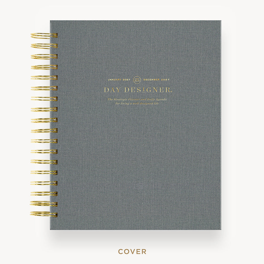 Gray planner with gold wire binding and 'Day Designer' branding on a white background