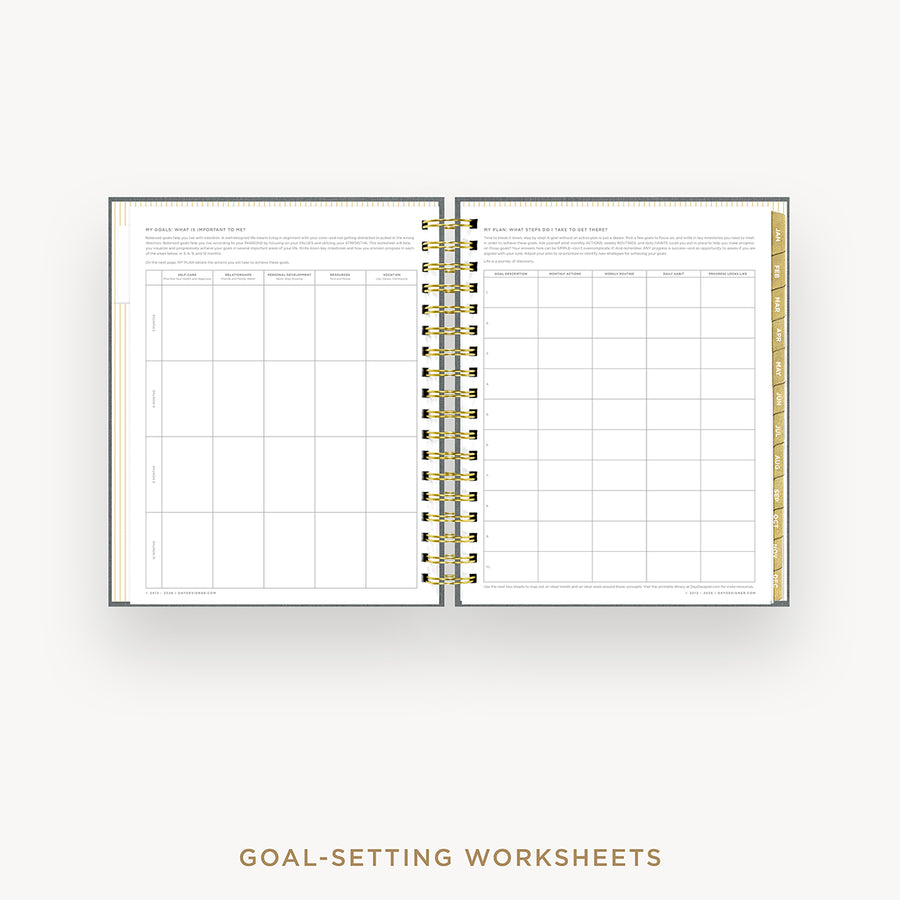Open spiral-bound notebook displaying goal-setting worksheets on a white background.