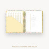 Open planner showing pages with pocket, stickers, and ruler on a white background