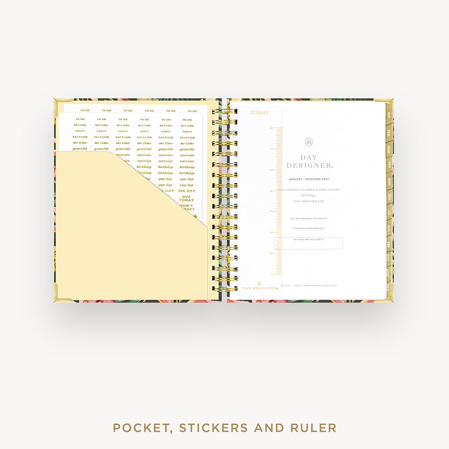 Open planner showing pages with pocket, stickers, and ruler on a white background