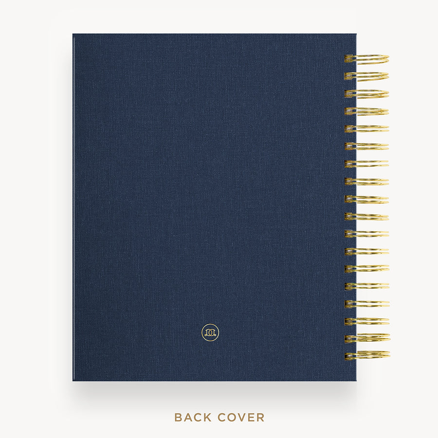 Navy blue planner with gold spiral binding on a white background