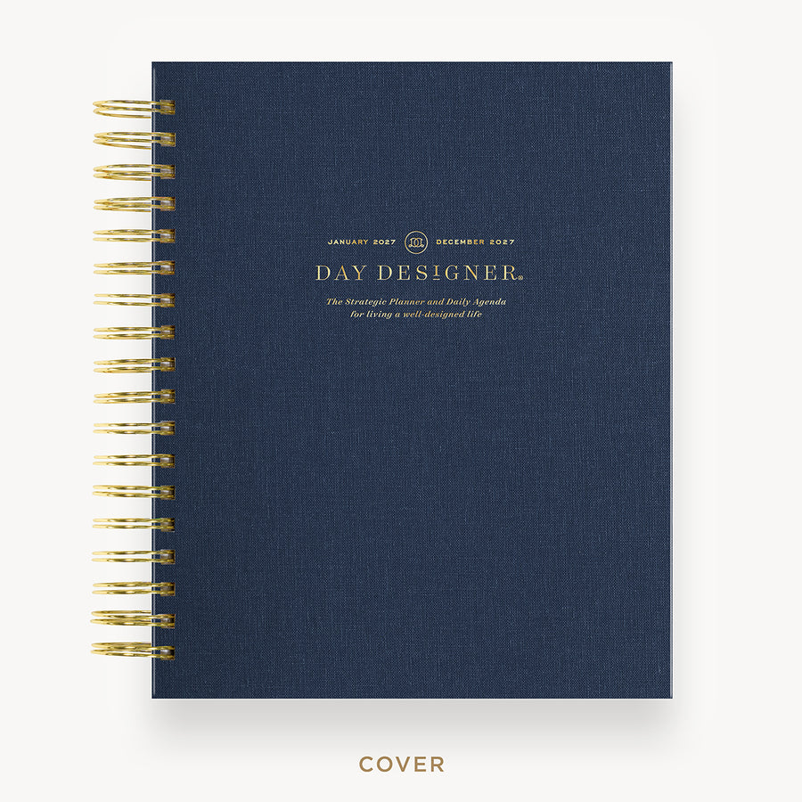 Navy blue planner with gold spiral binding on a white background