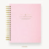 Pink planner with gold accents on a white background