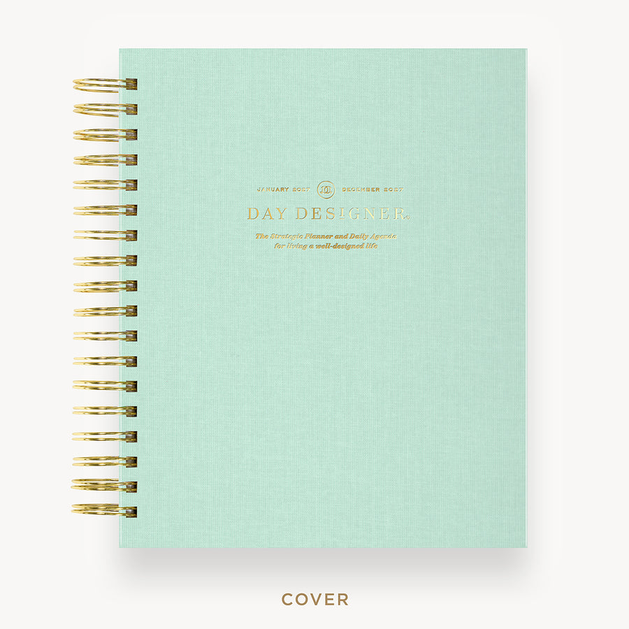 Mint green planner cover with gold spiral binding on a white background