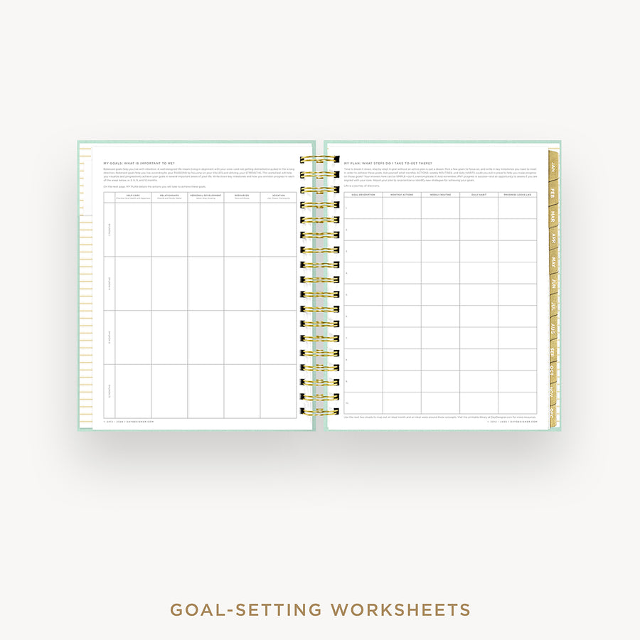 Open planner with goal-setting worksheets on a white background