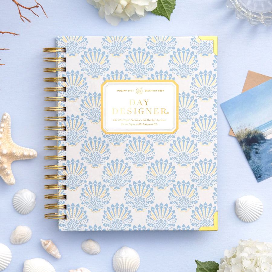 Notebook with shell pattern on a light blue background with decorative elements
