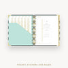 Open planner showing pages with a pocket, stickers, and ruler on a white background
