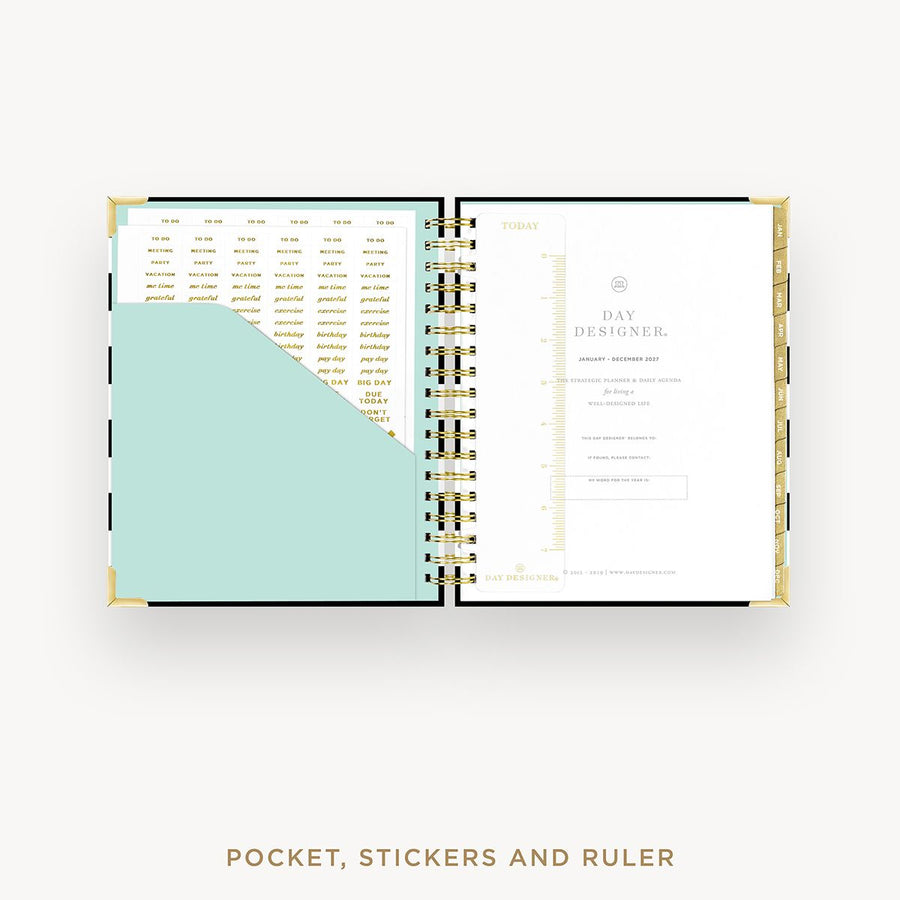 Open planner showing pages with a pocket, stickers, and ruler on a white background