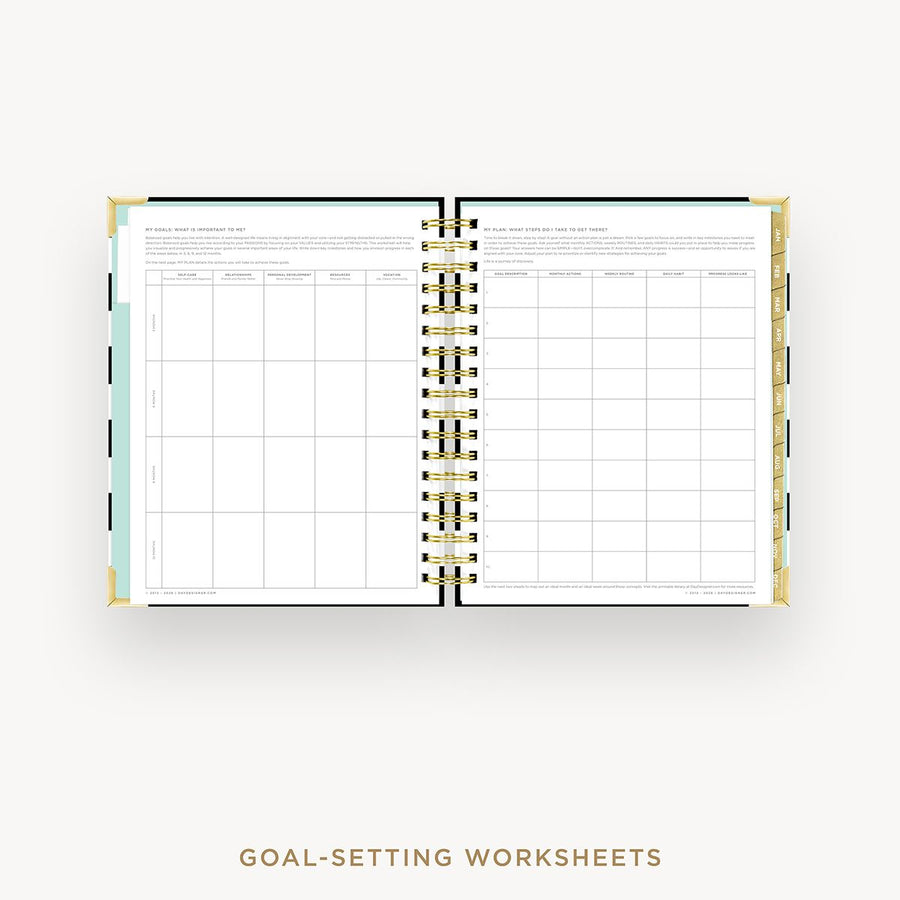 Open wire-bound notebook displaying goal-setting worksheets on a white background.