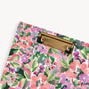 close up of red, purple, pink, green floral pattern clipfolio with gold clip on a cream background