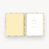 Spiral-bound planner with a floral cover on a white background