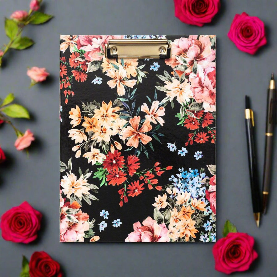 black clipfolio with beautiful flower assortment, gray background, red and pink roses, black pens