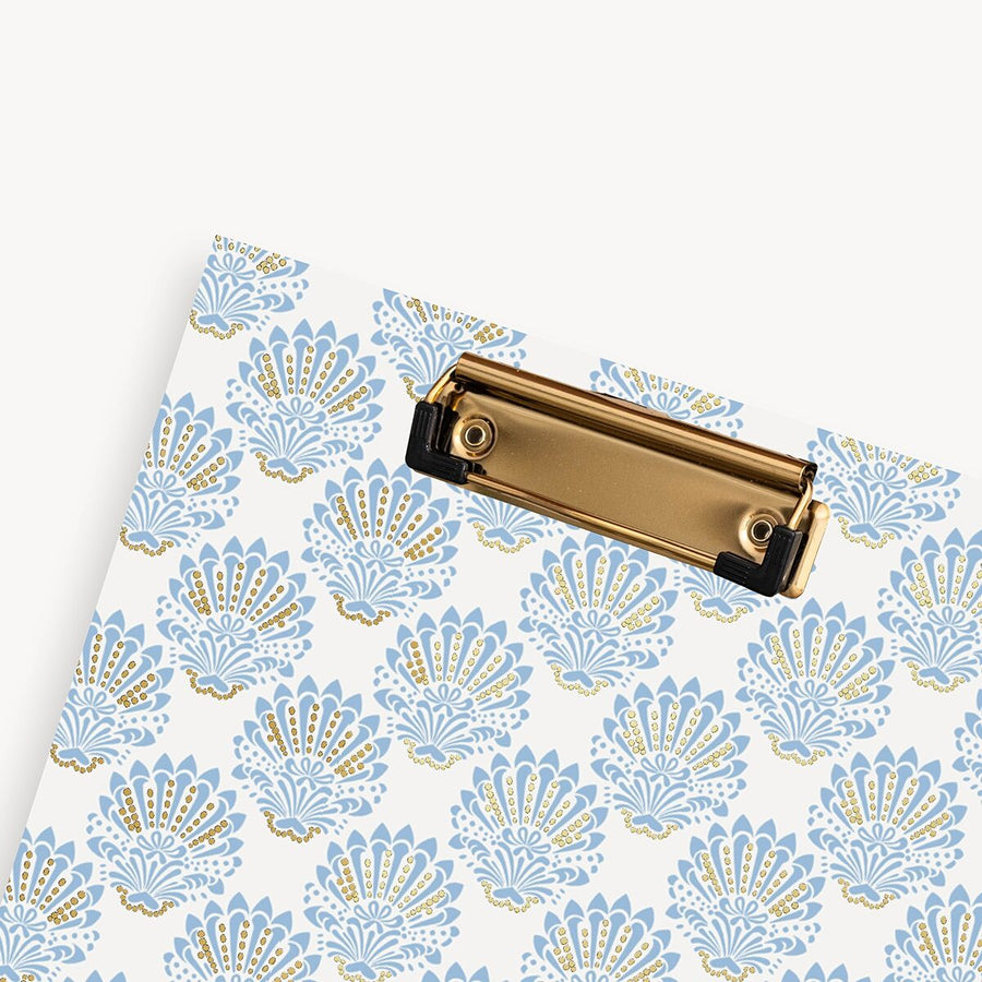 Patterned paper with a gold clip on a white background