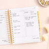 Day Designer 2026 daily planner: peony bookcloth opened with writing on it
