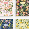 Four floral-patterned notebooks on a white background