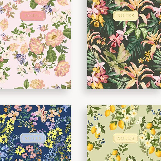 Four floral-patterned notebooks on a white background
