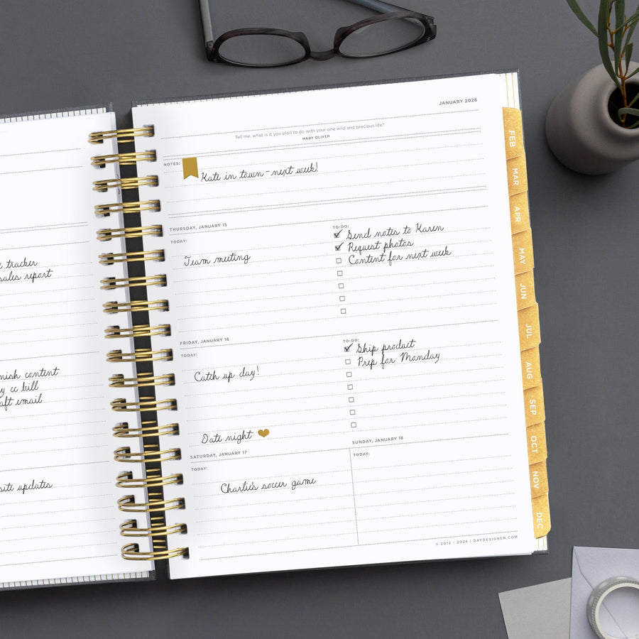 Day Designer 2026 weekly planner: charcoal bookcloth opened with writing on it