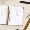 Day Designer 2026 mini daily planner: classic black pebble texture opened with writing on it