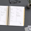 Day Designer 2026 mini daily planner: charcoal bookcloth opened with writing on it
