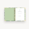 open mini notebook with green liner, gold binding, day designer title page