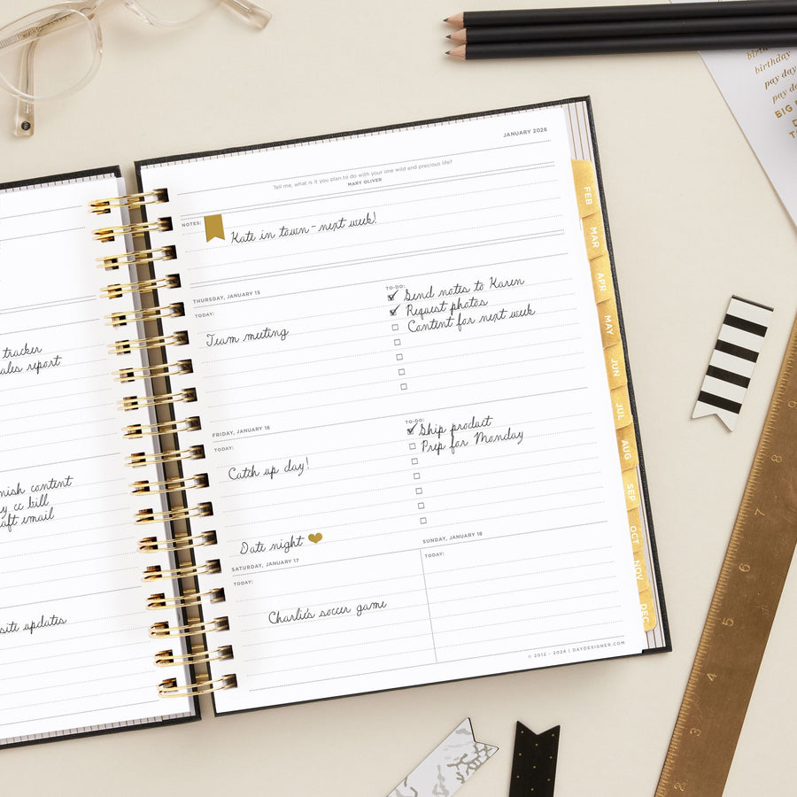 Day Designer 2026 weekly planner: classic black pebble texture opened with writing on it