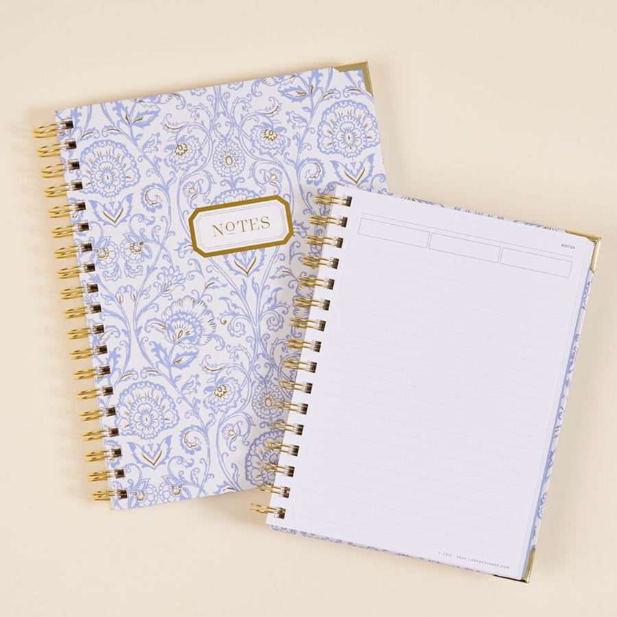 stacked notebooks in alicia pattern, beige background