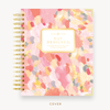 Day Designer's 2023 Weekly Planner with Sunset hard cover and gold spiral binding.