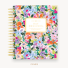 Day Designer's 2023 Weekly Planner with Blurred Spring hard cover and gold spiral binding.
