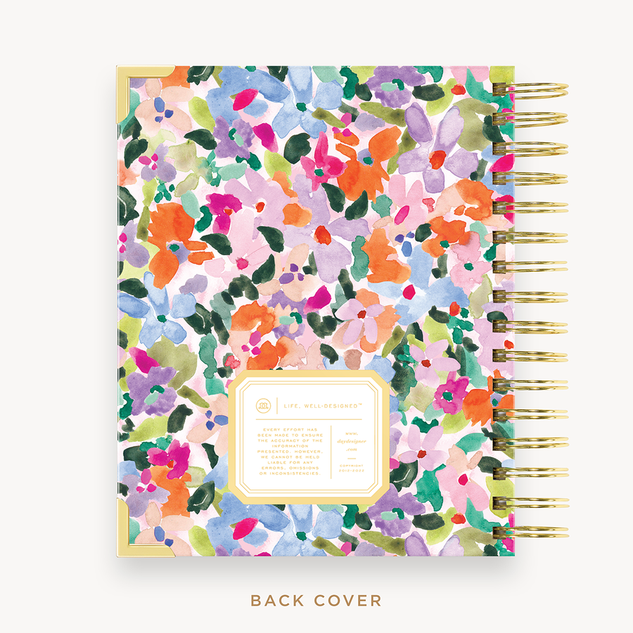 Day Designer's 2023 Daily Mini Planner with Blurred Spring back cover and gold spiral binding.