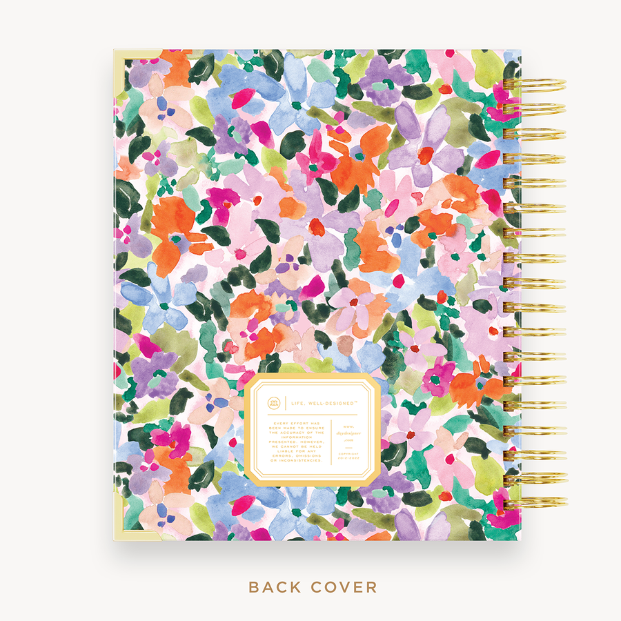Day Designer's 2023 Weekly Planner with Blurred Spring back cover and gold spiral binding.