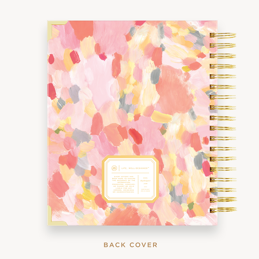 Day Designer's 2023 Weekly Planner with Sunset back cover and gold spiral binding.