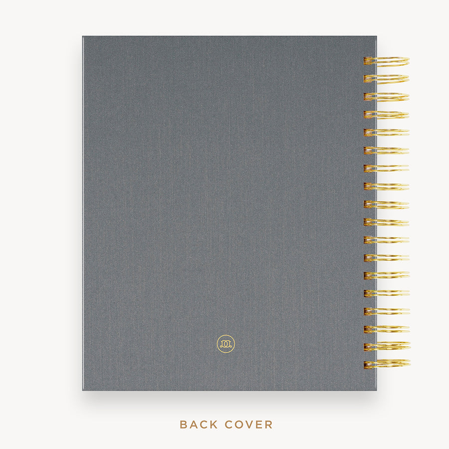 Day Designer's 2023 Daily Planner with Charcoal Bookcloth back cover and gold spiral binding.
