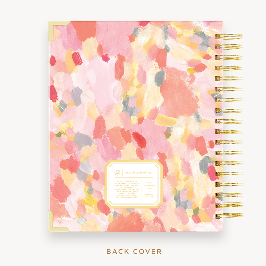 Day Designer's 2023 Daily Planner with Sunset back cover and gold spiral binding.