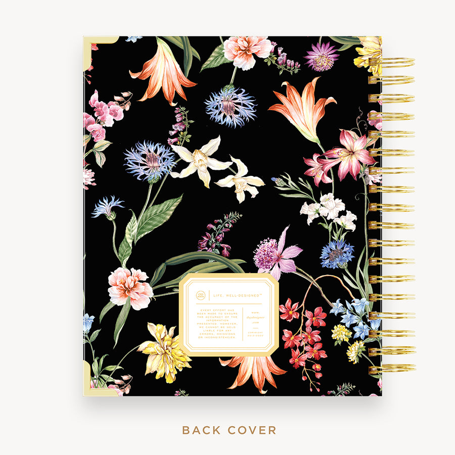 Day Designer's 2023 Daily Planner with Wild Blooms back cover and gold spiral binding.